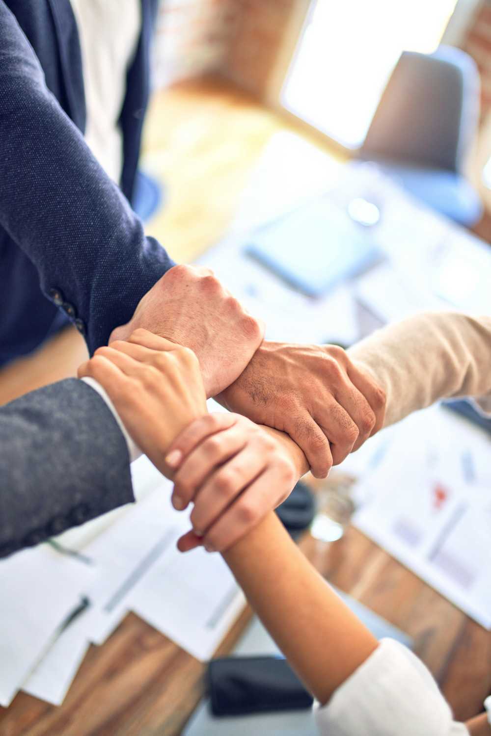 Four people holding hands together