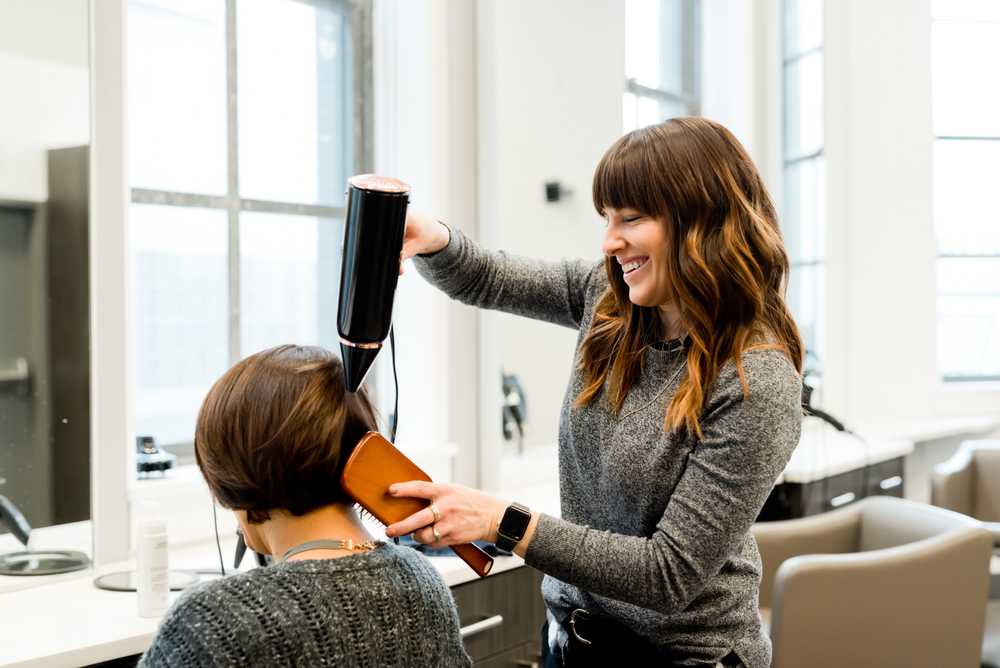 Hairstylist blow drying hair